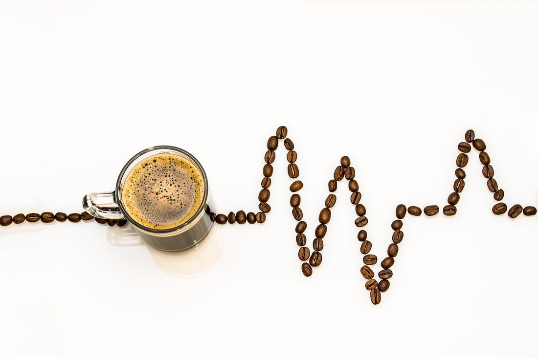 A Coffee cup and hearbeat sign made with beans